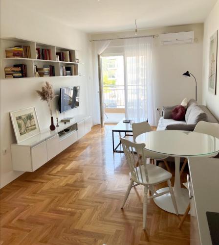 uma sala de estar com uma mesa e um sofá em Apartman Jelena em Trebinje