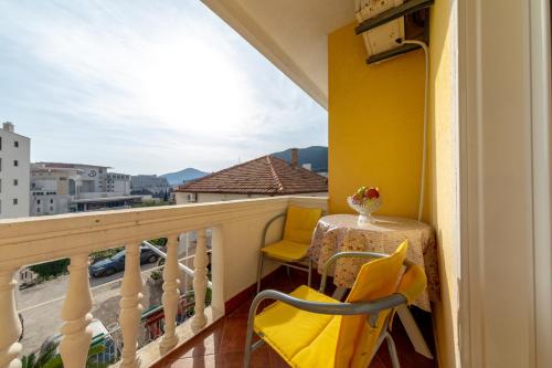 a balcony with a table and chairs and a view at Porta Volta Apartments in Becici