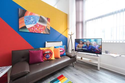 a living room with a couch and a flat screen tv at Stylish Stunning City Centre Jesouth Open Plan Boutique Pad in Hull
