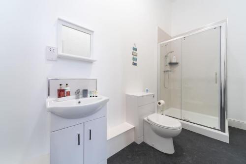 a white bathroom with a toilet and a sink at Stylish Stunning City Centre Jesouth Boutique Pad in Hull