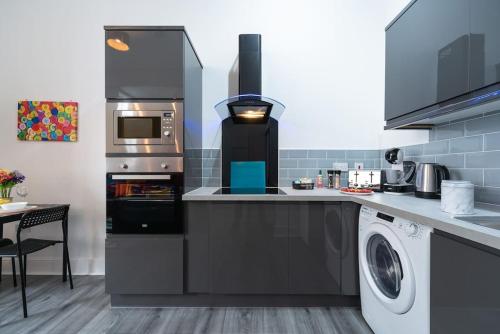 a kitchen with a dishwasher and a washer at Stylish Stunning City Centre Jesouth Open Plan Boutique Pad in Hull