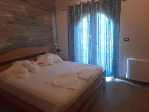 a bedroom with a bed with towels on it at Bujtina Te Xhako in Përmet