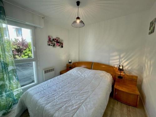 une chambre avec un grand lit et une fenêtre dans l'établissement Appartement T3 48m² centre-ville Quiberon - Plage, commerces, balcon, garage, 4 pers - FR-1-478-224, à Quiberon