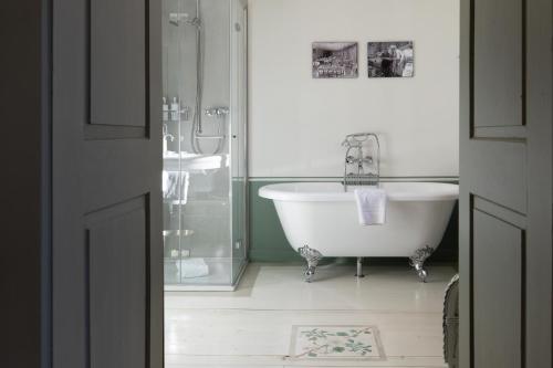 La salle de bains est pourvue d'une baignoire, d'une douche et d'un lavabo. dans l'établissement Hôtel Bella Tola & SPA, à Saint-Luc