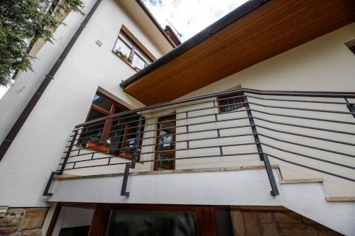 a house with a balcony with potted plants on it at Penzion Sonáta in Luhačovice