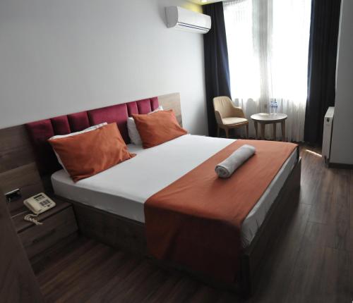 a bedroom with a large bed with a red headboard at Waha Hotel in Bursa