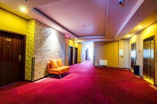 an empty hallway with a chair and a brick wall at Springs Hotel Ulaanbaatar in Ulaanbaatar
