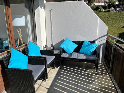 a patio with chairs and blue pillows on a balcony at Apartment near Laax Lake in Laax