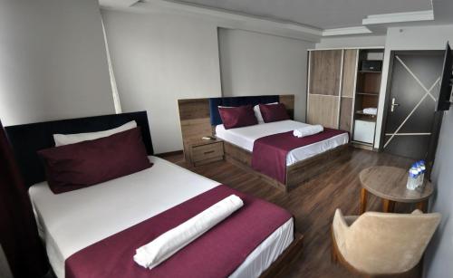a hotel room with two beds and a table at Waha Hotel in Bursa