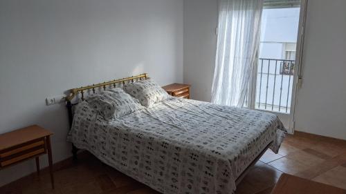 1 dormitorio con cama y ventana en Cómodo piso en Cardeña (Córdoba), en Cardeña