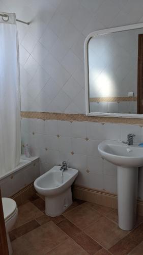 a bathroom with a sink and a toilet and a mirror at Cómodo piso en Cardeña (Córdoba) in Cardeña