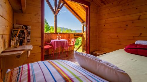 ein Schlafzimmer mit einem Bett in einem Blockhaus in der Unterkunft Robinzonski turizam "Robin` s Hood" in Skrad