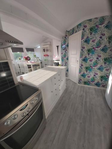 uma cozinha com balcões brancos e um forno com placa de fogão em Solstua em Sandefjord