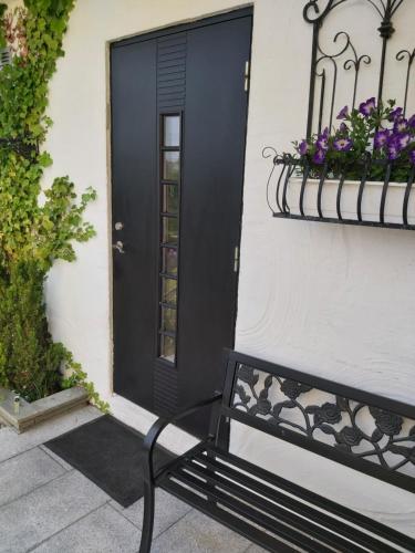 a black door and a bench in front of a house at Solstua in Sandefjord