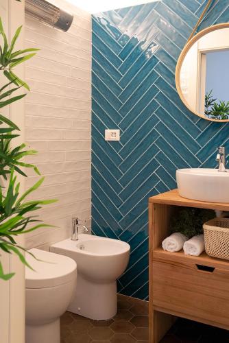 a bathroom with a toilet sink and a mirror at Ensemble rooms di Vayadù in Alassio