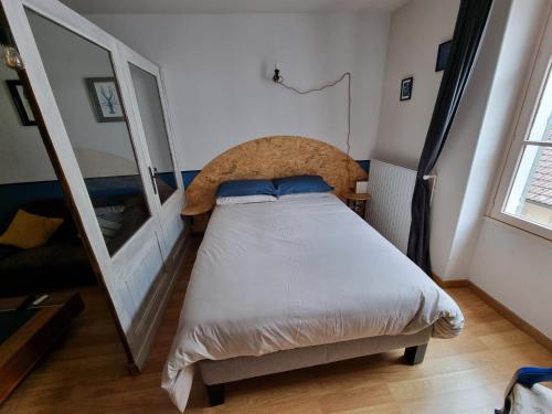 een kleine slaapkamer met een bed en een spiegel bij L'écrevisse in Nantua