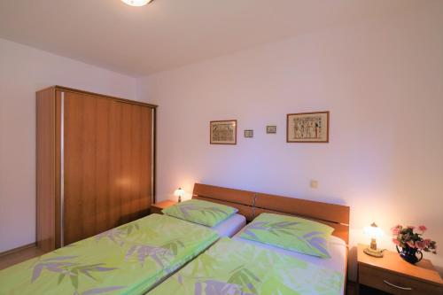 a bedroom with a bed and a wooden headboard at Apartments Coral, Klimno, island Krk in Klimno