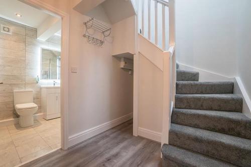 a hallway with a staircase and a bathroom with a toilet at The Queens Arms Apartments in Liverpool