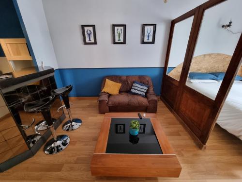 ein Wohnzimmer mit einem Bett und einem Tisch in der Unterkunft L'écrevisse in Nantua