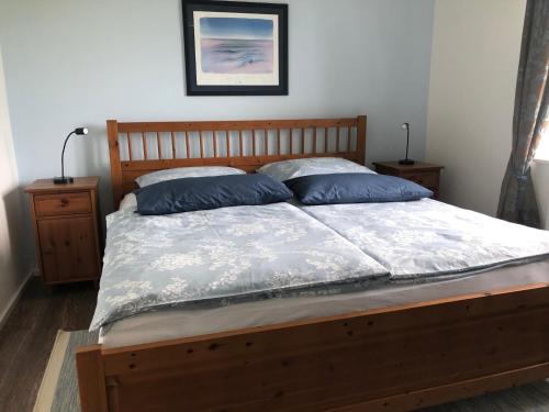 Un dormitorio con una cama con almohadas azules. en La belle vue, en Born