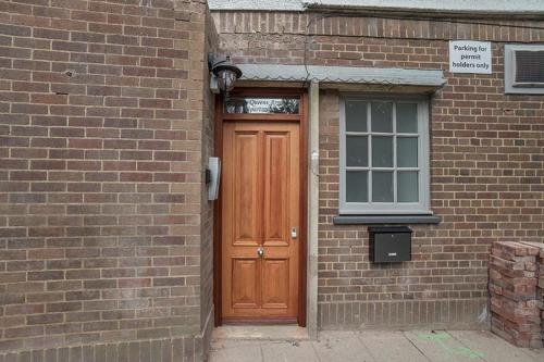 a brick building with a wooden door and a window at The Queens Arms Apartments in Liverpool