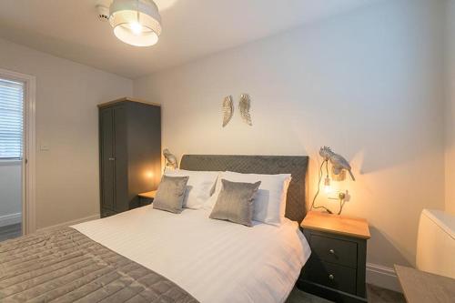 a bedroom with a large bed with two lamps and a nightstand at The Queens Arms Apartments in Liverpool