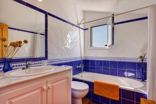 a bathroom with a tub and a toilet and a sink at Villa Maggie by Villa Plus in Cala en Blanes
