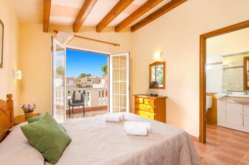 a bedroom with a large bed and a balcony at Villa Martinur by Villa Plus in Cala en Blanes