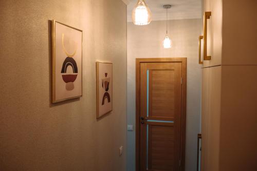a hallway with a door and two pictures on the wall at 2 bedroom central flat in Jelgava