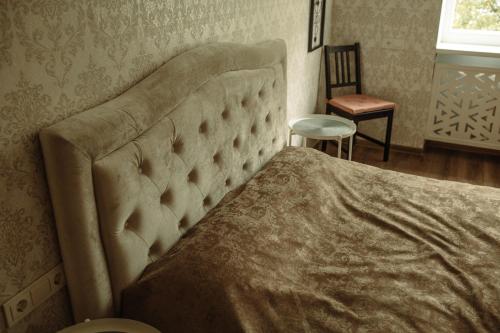 um quarto com uma cama, uma cadeira e uma janela em 2 bedroom central flat em Jelgava