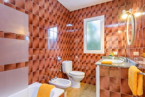 un baño con inodoro y lavabo en Villa Isi by Villa Plus, en Cala en Blanes