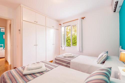 Un dormitorio con dos camas y una ventana. en Villa Isi by Villa Plus, en Cala en Blanes