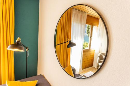 a round mirror on a wall in a room at Seehotel Sternen in Brienz