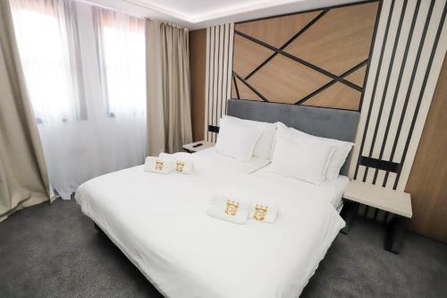 a bedroom with a large bed with white sheets and pillows at Glavatarski Han in Glavatartsi