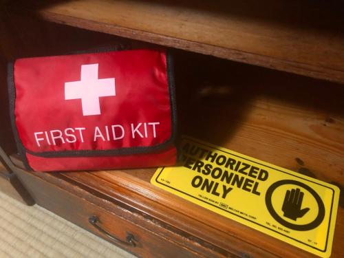 a first aid kit and a first aid sign on a drawer at Tomo's INN - priceless experience - in Obu