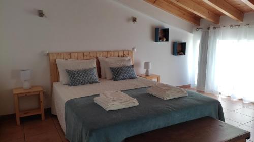 a bedroom with a bed with two towels on it at Casa Ermelinda in Aljezur