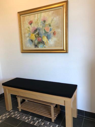a bench in a room with a painting on the wall at La belle vue in Born