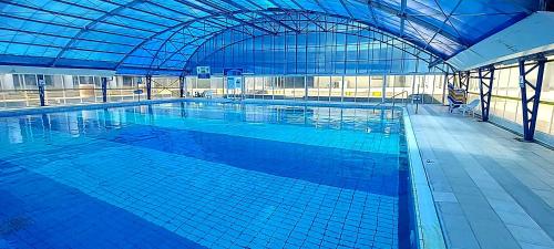 a large swimming pool in a large building at Hotel Apartment Short Term Tel Aviv Bat Yam 5 in Bat Yam