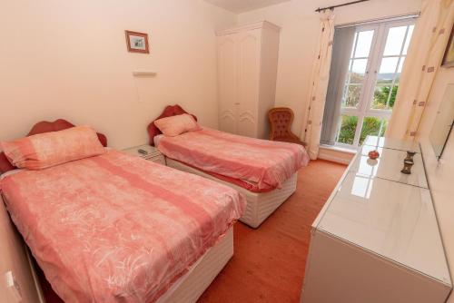 a bedroom with two beds and a window at Barton House in Woolacombe
