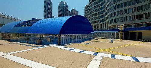 a large blue building in a city with tall buildings at Hotel Apartment Short Term Tel Aviv Bat Yam 5 in Bat Yam