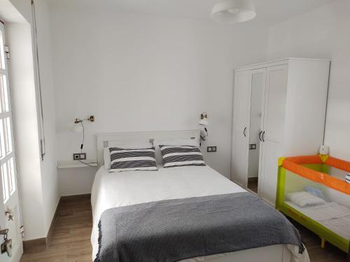 1 dormitorio con 1 cama blanca grande y 2 almohadas en Villa Kai Casa frente al mar y completamente restaurada, en Santa Cruz das Flores