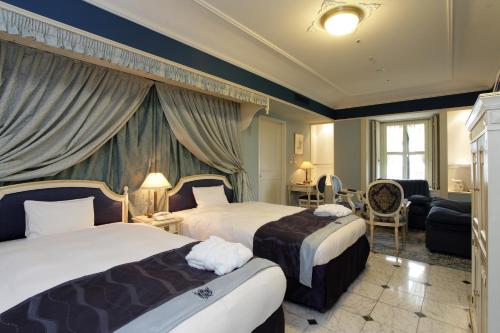 a hotel room with two beds and a living room at Hotel Monterey Osaka in Osaka