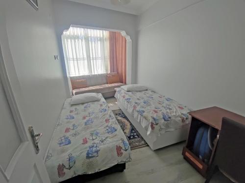 Habitación con 2 camas y TV. en GÜVEN PANSİYON, en Amasra
