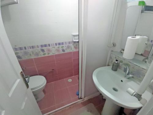 y baño con lavabo, aseo y ducha. en GÜVEN PANSİYON, en Amasra