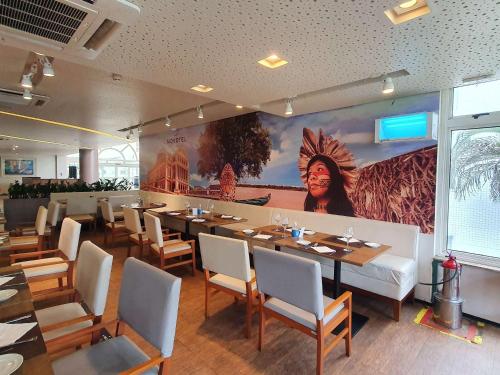 a dining room with a large painting on the wall at Novotel Manaus in Manaus