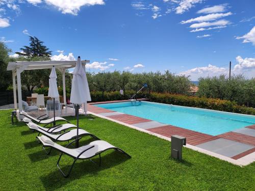 a group of chairs next to a swimming pool at Casa Roby in Bardolino