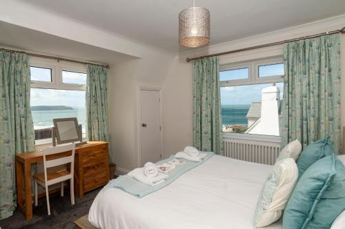 a bedroom with a bed and a desk with a window at Coastal Retreat in Woolacombe