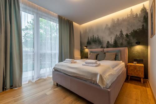 um quarto com uma cama grande e uma janela grande em SZARY WILK Apartament Szczyrk em Szczyrk