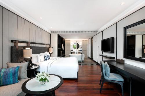 a hotel room with a bed and a desk at Melia Koh Samui in Choeng Mon Beach