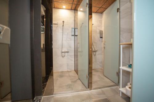 a shower with a glass door in a bathroom at Corner Hostel & Cafe in Taipei